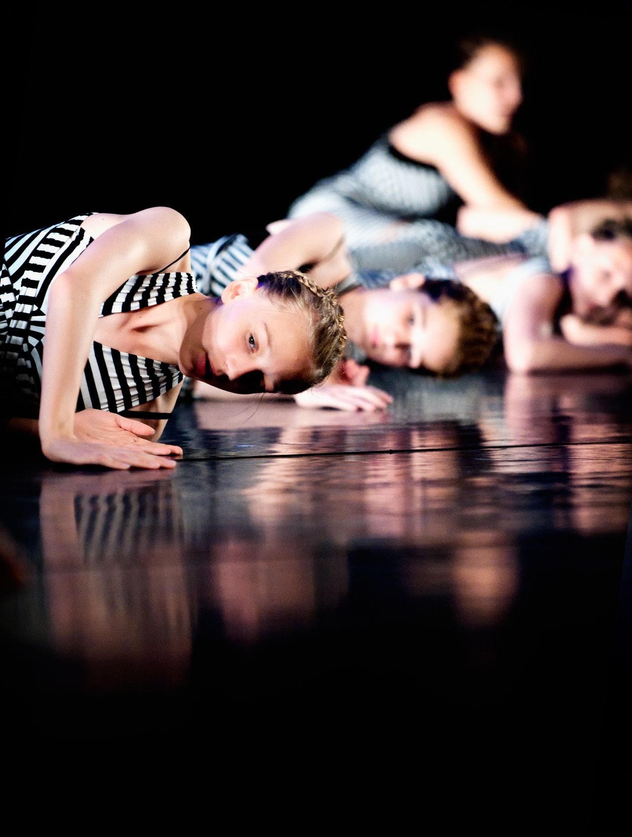 Danseres in gestreepte outfit op reflecterende vloer