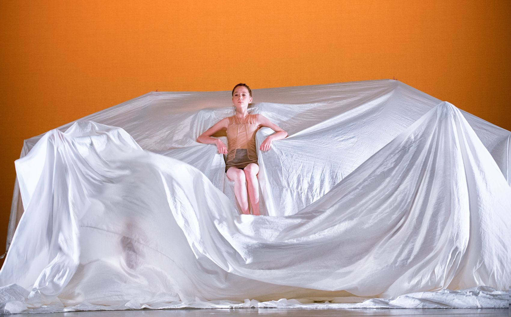 Danseres met grote lap stof, warme achtergrond
