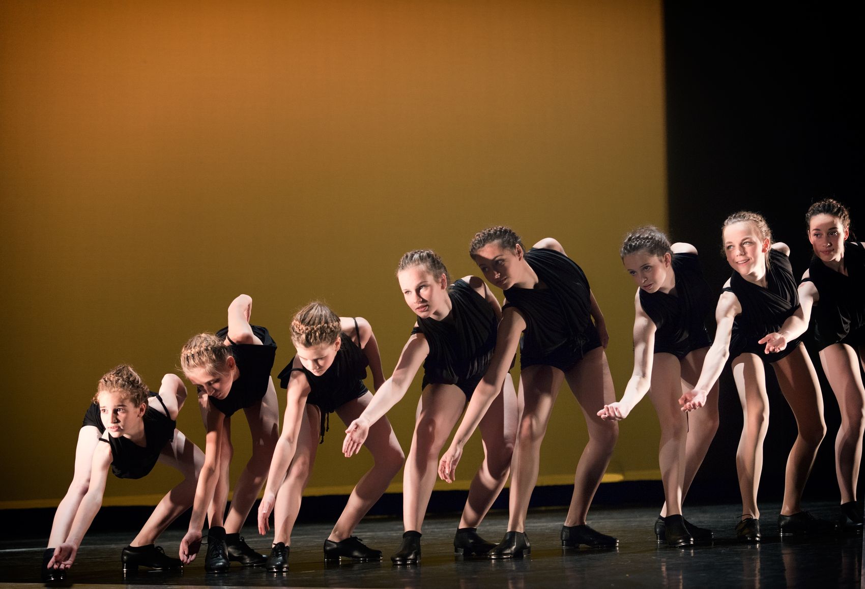 Groep dansers in tapschoenen op het podium